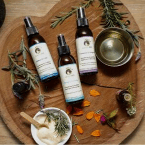 Genki Pet Aromatherapy for pets and their people three bottles of behaviour changing spritzes on natural wood with herbs and essential oils and flowers